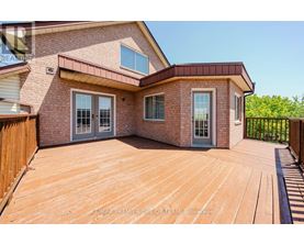 A house with a wooden deck and a brick exterior.