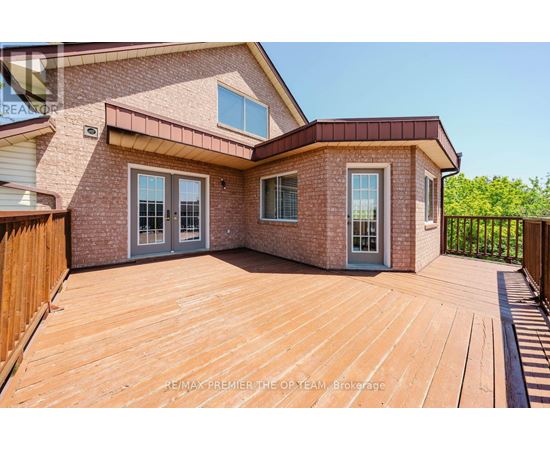 A house with a wooden deck and a brick exterior.