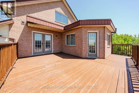A house with a wooden deck and a brick exterior.