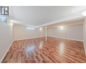 A room with wooden flooring and white walls, likely a bedroom or office space.