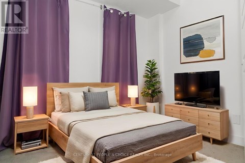 A bedroom with a bed, nightstand, and a television.