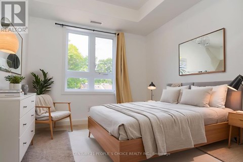 A bedroom with a bed, nightstand, chair, and window.