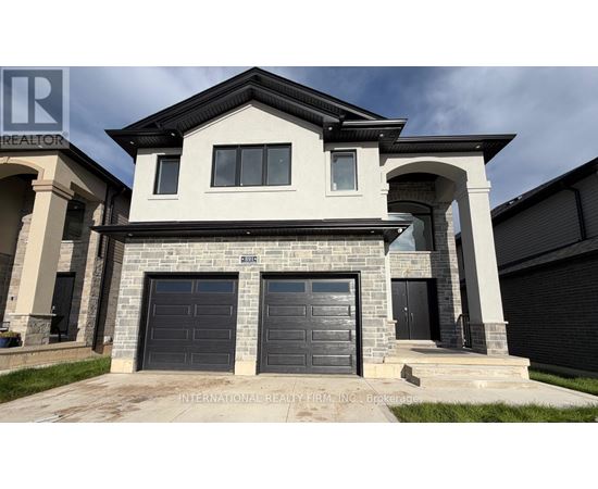 A modern house with a stone facade and two garage doors.