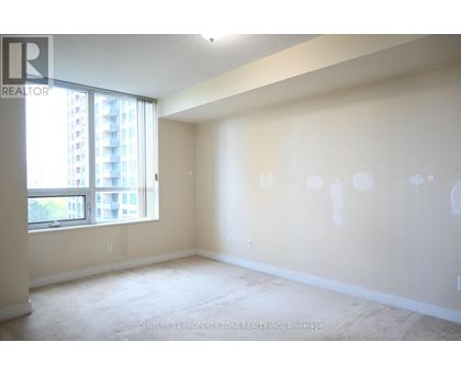 A spacious room with a large window and a view of a building outside.