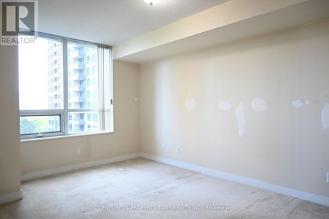 A spacious room with a large window and a view of a building outside.