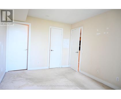 A room with three doors and a carpeted floor.