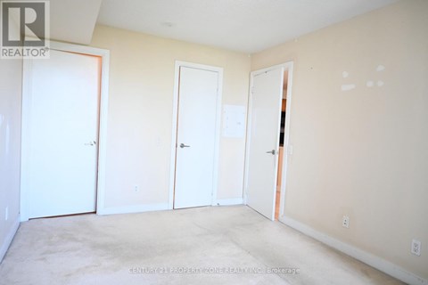 A room with three doors and a carpeted floor.