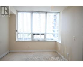 A room with a large window and a view of a building outside.