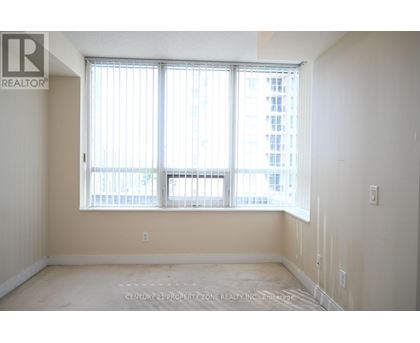 A room with a large window and a view of a building outside.