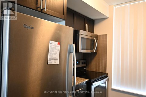 A stainless steel refrigerator with a note attached to it.
