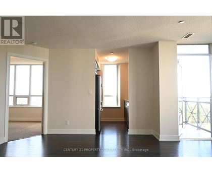A spacious room with a door in the middle and windows on the wall.