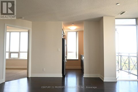 A spacious room with a door in the middle and windows on the wall.