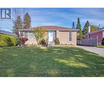 A house with a lawn and trees in front of it.