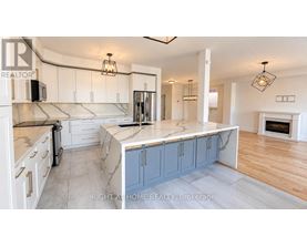 A kitchen with a marble countertop and a fireplace in the background.