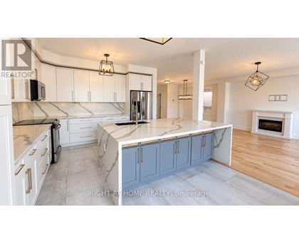 A kitchen with a marble countertop and a fireplace in the background.