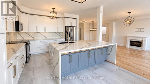 A kitchen with a marble countertop and a fireplace in the background.
