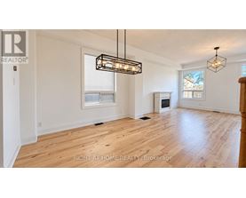 A spacious room with wooden flooring and a large window.