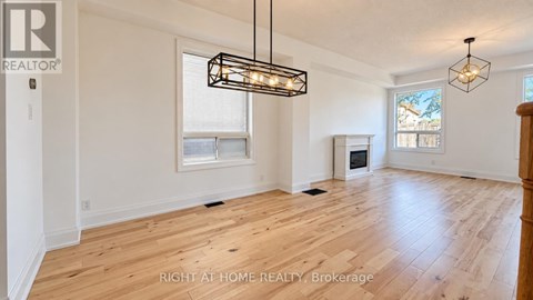 A spacious room with wooden flooring and a large window.