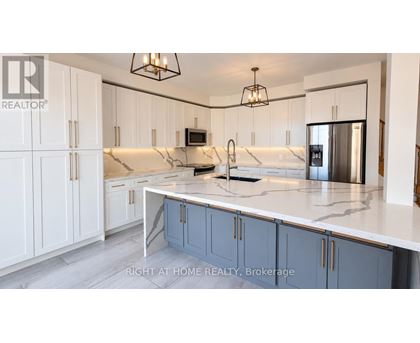 A kitchen with white cabinets and a marble countertop.