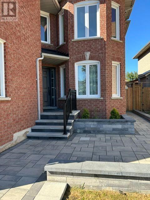 A brick house with a black door and steps leading to the entrance.