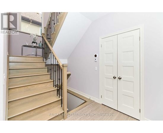 A white door is in a room with a staircase.