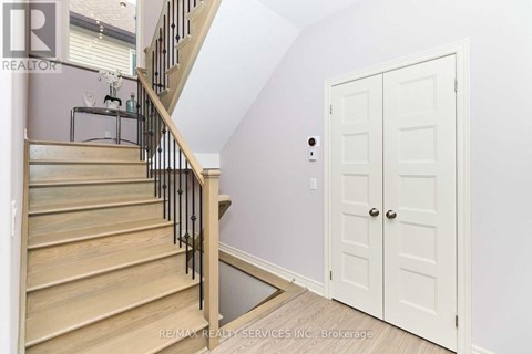 A white door is in a room with a staircase.