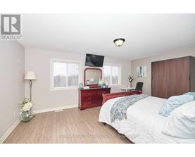 A bedroom with a red dresser and a bed with white bedding.