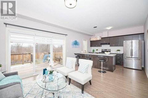 A modern kitchen with a glass table and chairs, and a view of a deck outside the window.