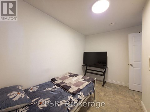 A bedroom with a bed and a television in it.