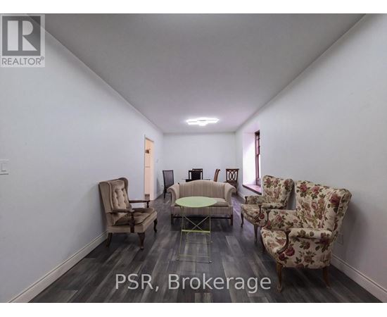 A living room with a couch, chairs, and a table.