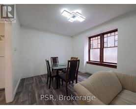 A dining room with a table set for two and a sofa.