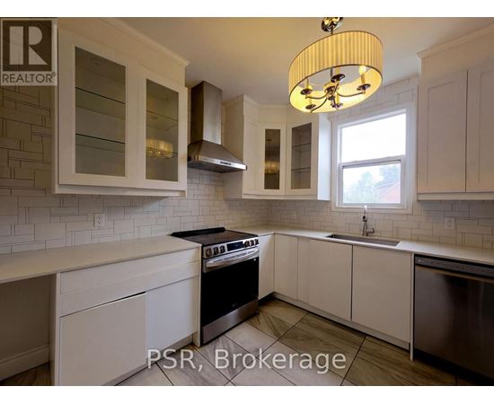 A kitchen with white cabinets and a black stove top oven.