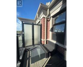 A balcony with a glass door and a brick pillar.