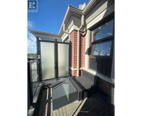 A balcony with a glass door and a brick pillar.