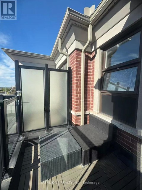 A balcony with a glass door and a brick pillar.
