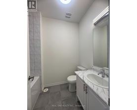 A bathroom with a toilet, sink, and shower.