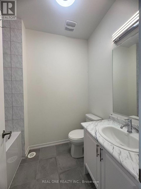 A bathroom with a toilet, sink, and shower.
