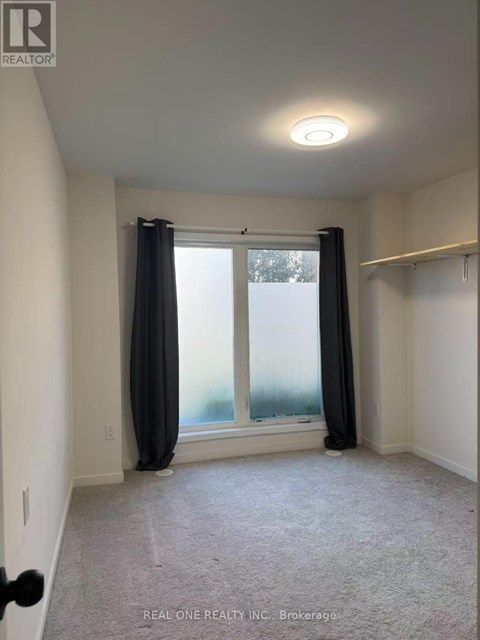 A room with a window and curtains, and a carpet on the floor.