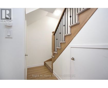 A staircase with a wooden banister and a white wall.