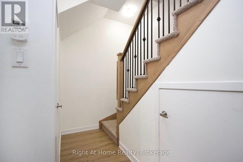 A staircase with a wooden banister and a white wall.