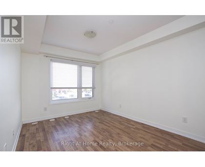 A room with wooden flooring and a window with blinds.