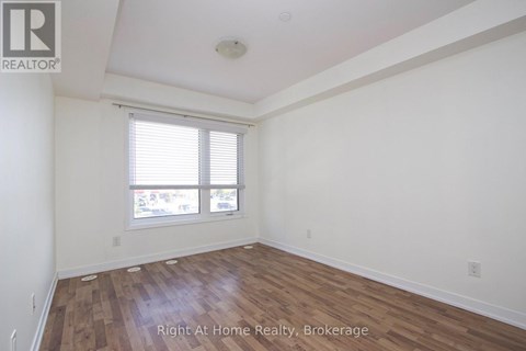 A room with wooden flooring and a window with blinds.