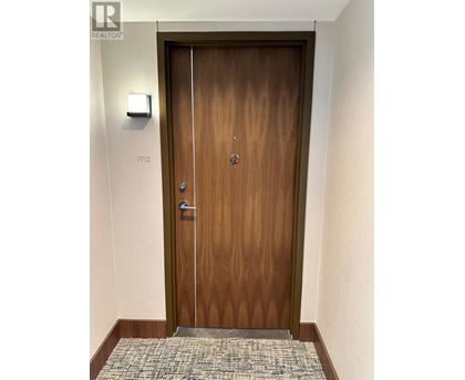 A wooden door with a glass panel and a handle.