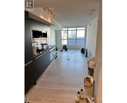 A kitchen with a black counter top and a white wall.