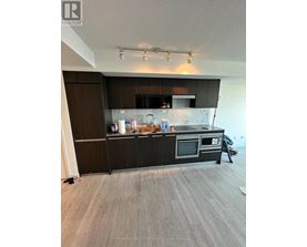 A kitchen with a black countertop and stainless steel appliances.