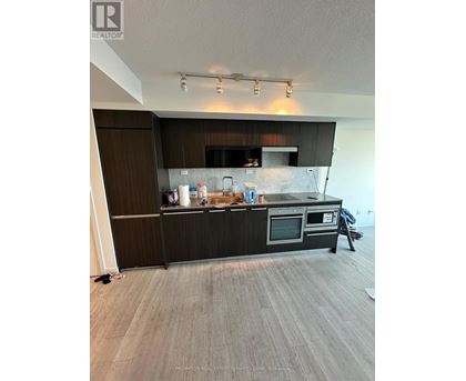 A kitchen with a black countertop and stainless steel appliances.