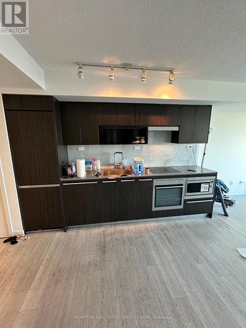 A kitchen with a black countertop and stainless steel appliances.