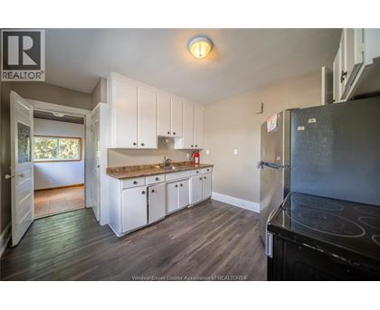 A kitchen with white cabinets and a black stove top oven.