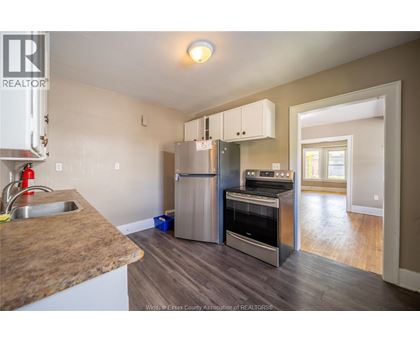 A kitchen with a refrigerator, oven, and sink.