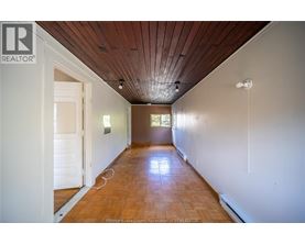 A long hallway with a wooden ceiling and floor.